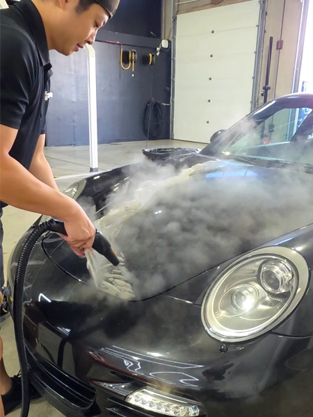 Technician carefully removing old PPF from Porsche 911